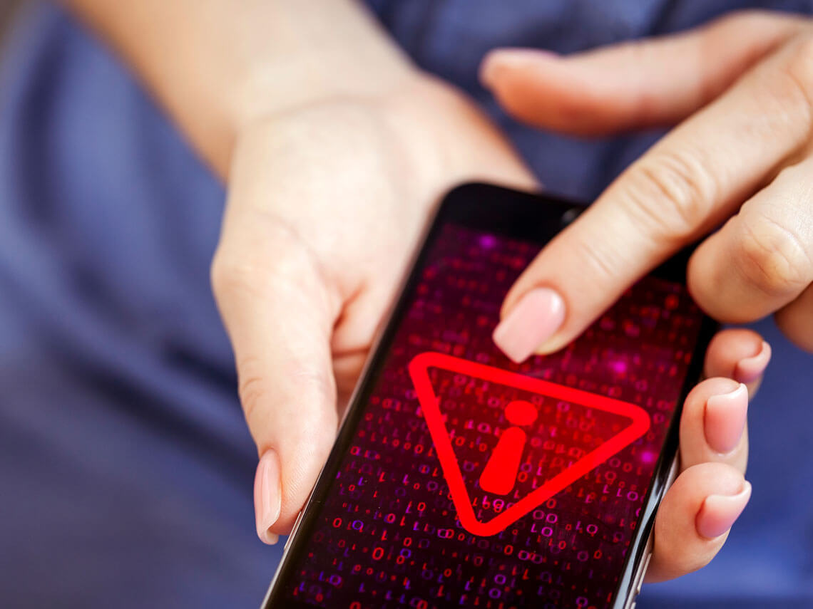 woman holding phone with warning sign symbolizing data breach crimes